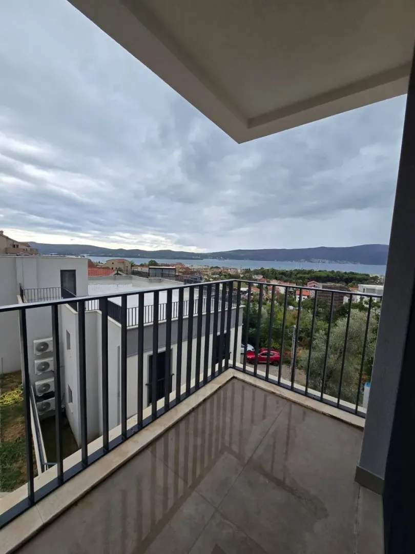Nenamješten balkon sa pogledom na more i okolno naselje.