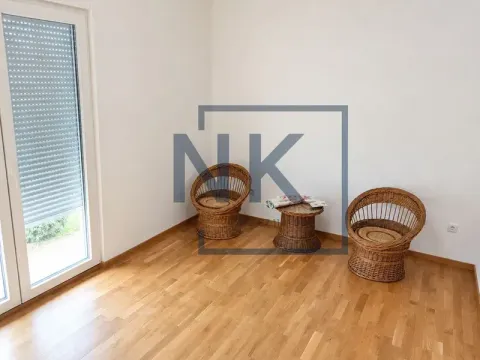 Prazna soba sa drvenim podom, pletenim stolicama i stolićem. - image 4