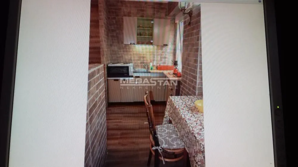 Small kitchen with a dining table and brick-clad walls.