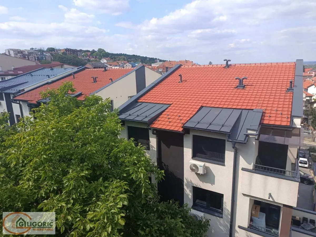Pogled sa terase na krovove zgrada i okolno naselje.