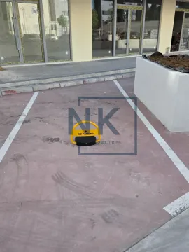 Marked parking space with a barrier in front of the building entrance. - image 17