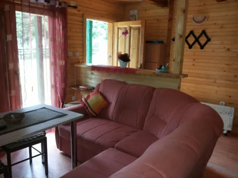 Dnevni boravak u drvenoj kući sa ugaonom garniturom i trpezarijskim stolom. - image 17
