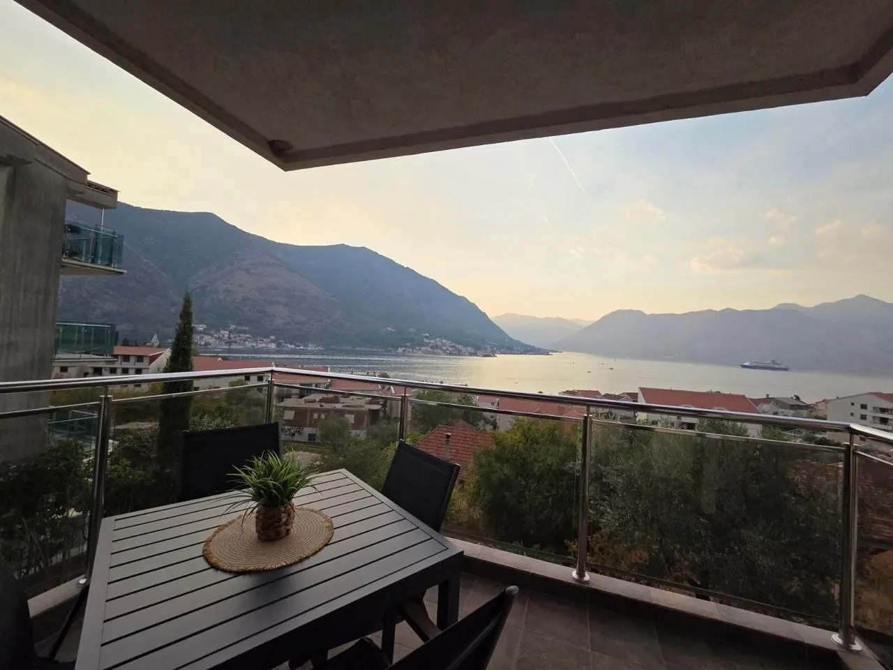 Furnished balcony with seating set and sea and mountain view.