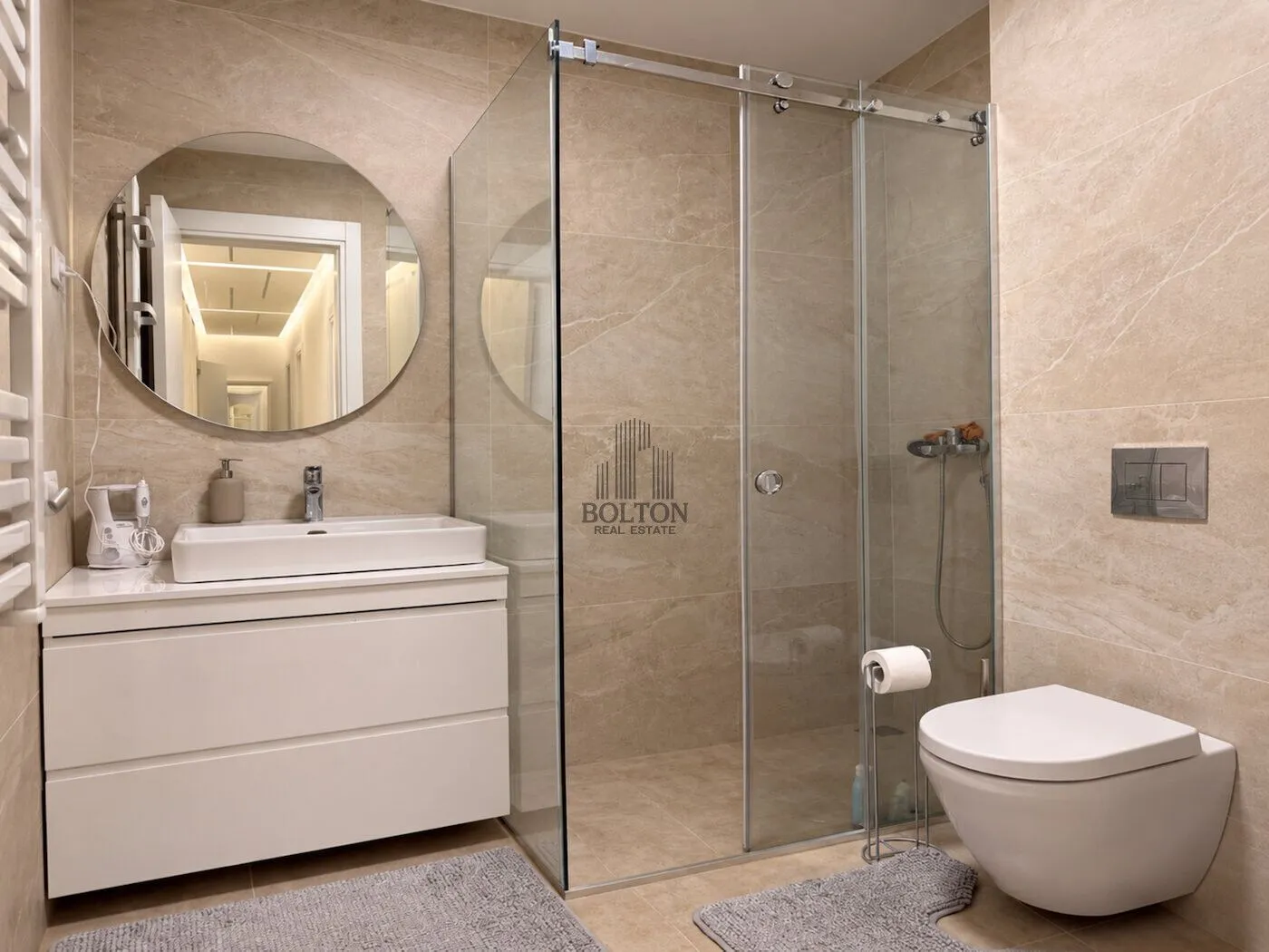 Modernly equipped bathroom with a walk-in shower, washbasin, and toilet.