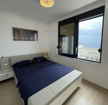 Bedroom with a double bed, window, and sea view. - image 6