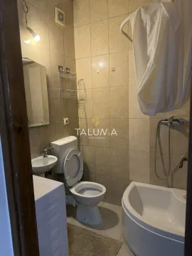Manje kupatilo obloženo keramičkim pločicama sa toaletom, umivaonikom i kadom. - image 4