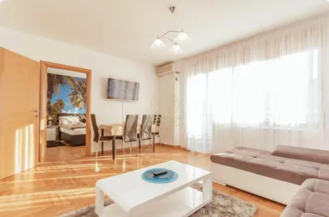Living room with a sofa, coffee table, and dining area. - image 4