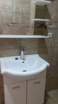 Bathroom sink with a white cabinet and a mirror. - image 4