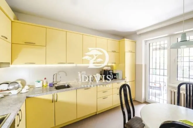 Kitchen with bright yellow cabinetry and a dining area.