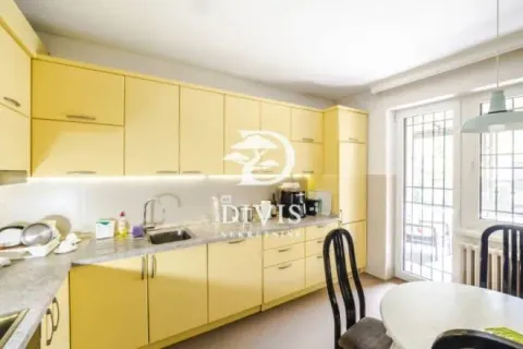 Kitchen with bright yellow cabinetry and a dining area. - image 12