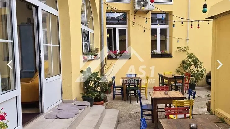 Pogled na spoljašnji dio objekta sa stolovima i stolicama.