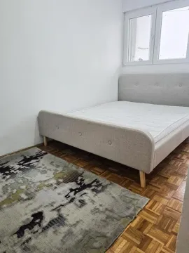 Spavaća soba sa bračnim krevetom, parketom i tepihom. - image 3