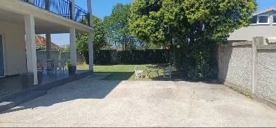 House yard with a paved area and green lawn. - image 8