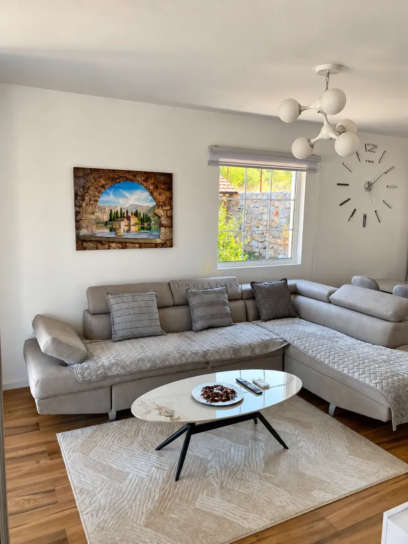 Living room with a corner sofa, coffee table and decorative details on the wall.