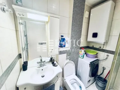 Smaller bathroom with a sink, toilet, and washing machine. - image 15