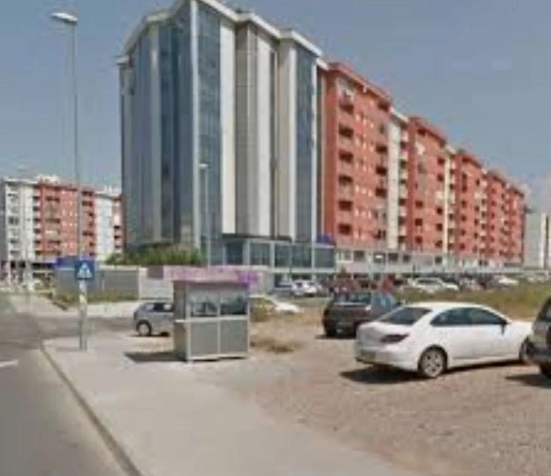 Exterior view of a modern residential building with outdoor parking.