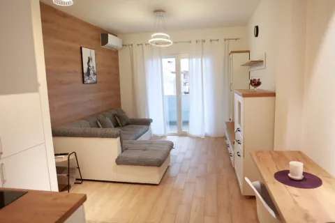 Living room with sofa, wooden wall paneling and access to the balcony. - image 2