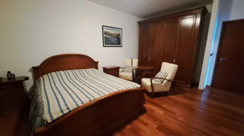 Spavaća soba sa bračnim krevetom, drvenim ormarom i foteljama. - image 6