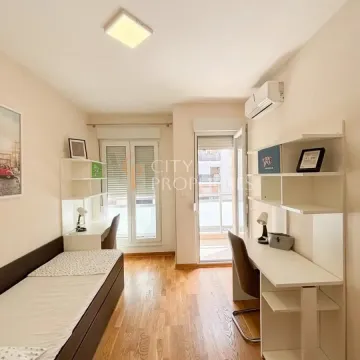 Namještena spavaća soba sa krevetom, radnim stolovima i izlazom na terasu. - image 7