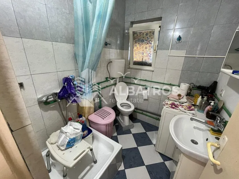 Kupatilo sa tuš kabinom, WC šoljom, umivaonikom i mašinom za veš.