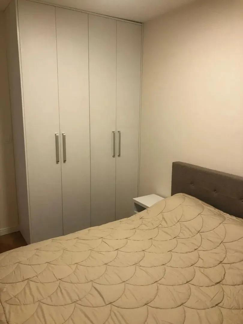 Spavaća soba sa bračnim krevetom i ugradnim ormarom.