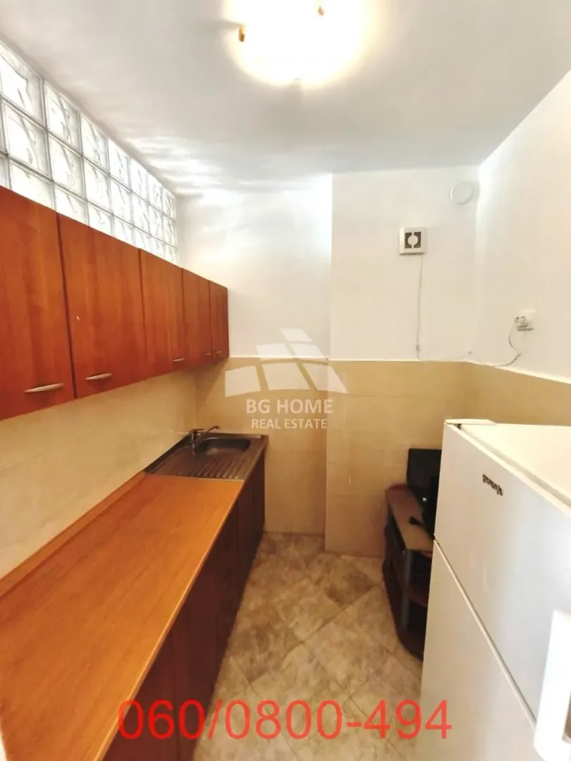 Smaller kitchen with wooden cabinets and a white refrigerator.