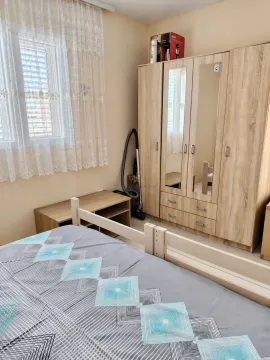 Furnished bedroom with a double bed, large wardrobe, and a window. - image 12