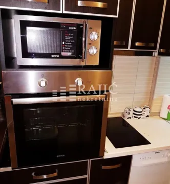 View of the built-in oven, microwave, and kitchen countertop. - image 6