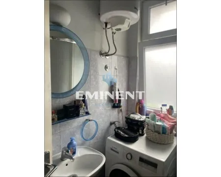View of the bathroom with a washbasin, mirror, water heater, and washing machine. - image 3