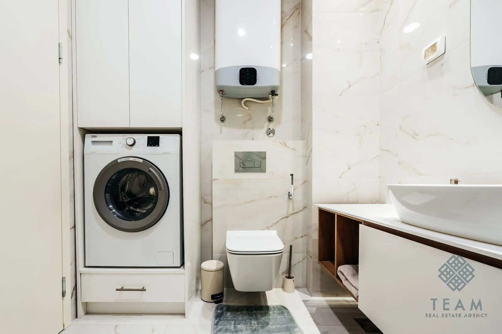 Modernly equipped bathroom with a washing machine and built-in units.