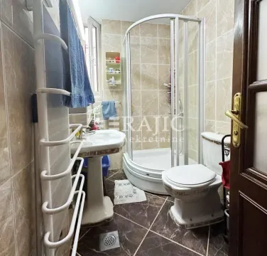 Smaller bathroom with a shower cabin, washbasin, and toilet. - image 6