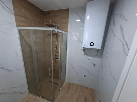 Modern bathroom with a shower cabin and water heater. - image 2