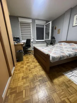 Nameštena spavaća soba sa bračnim krevetom, radnim stolom i parketom na podu. - image 3
