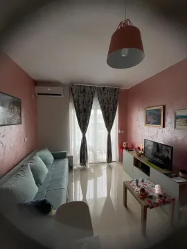 Living room with a sofa, TV, and coffee table. - image 10