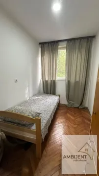 Smaller bedroom with a bed and a window with curtains. - image 4