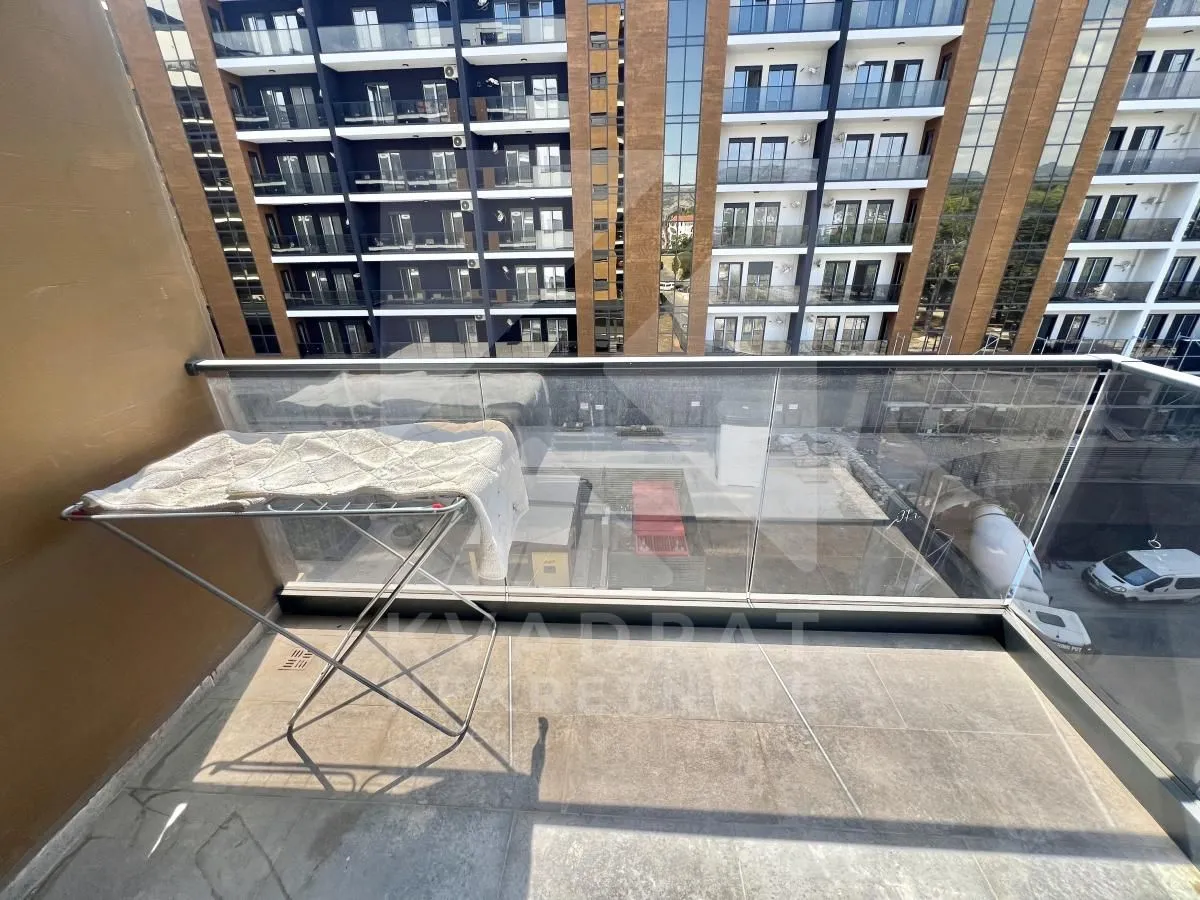 Manji balkon sa staklenom ogradom i sušilicom za veš.