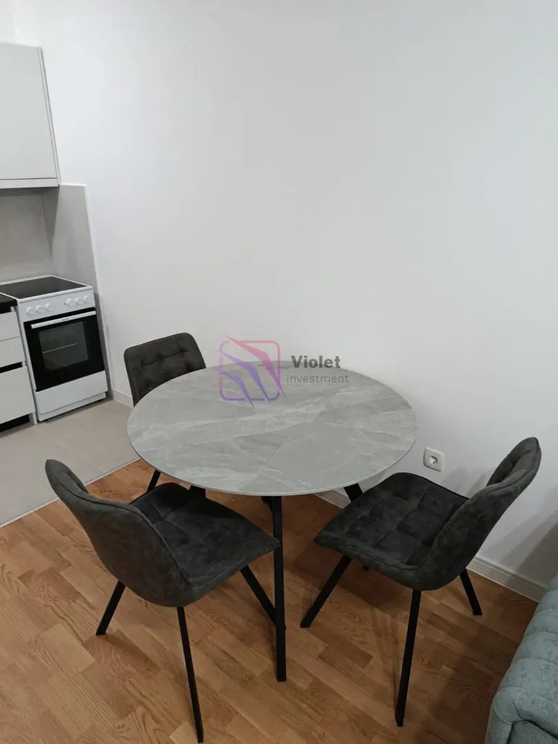 Dining table with four chairs as part of the living room.