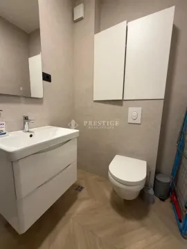 A modern bathroom equipped with a sink and toilet. - image 9