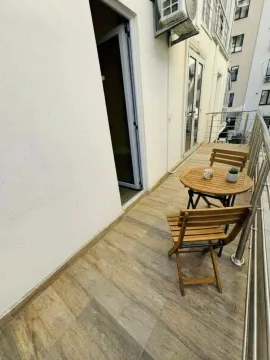 Uređena terasa sa drvenim stolom i stolicama. - image 9