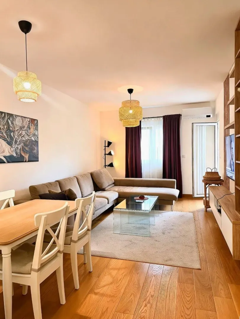 Udoban dnevni boravak sa garniturom, trpezarijskim stolom i modernim osvjetljenjem.