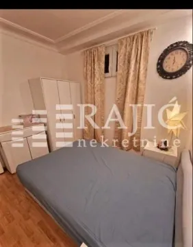 Furnished bedroom with a double bed, wardrobe, and a window with curtains. - image 7