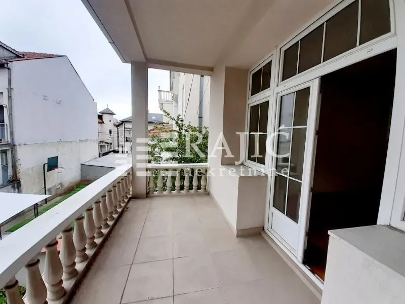 Spacious covered terrace with a view of surrounding buildings and the street.