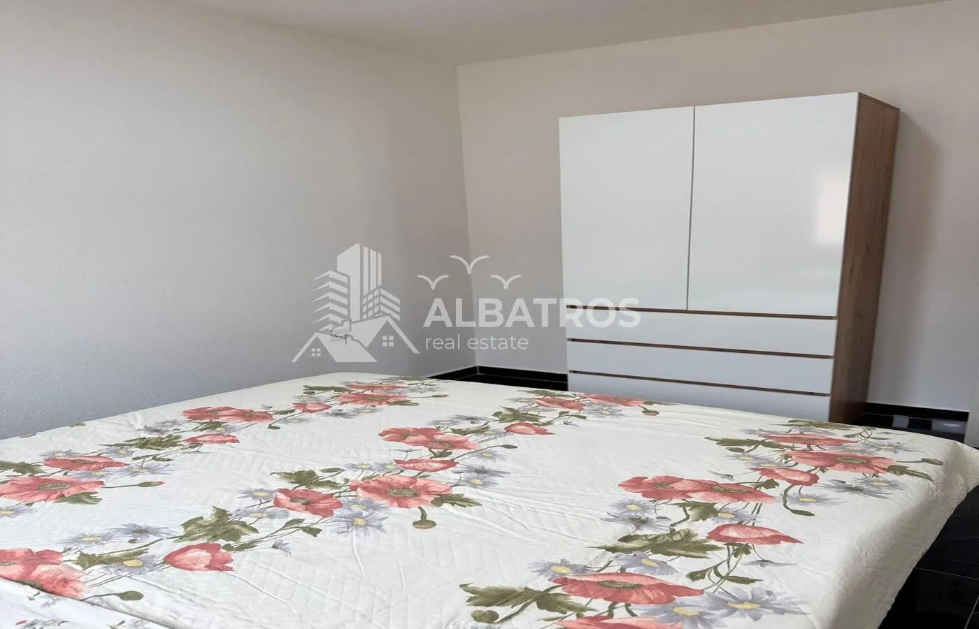 Bedroom with a double bed and a white wardrobe.