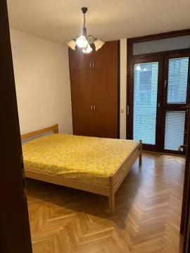 Spavaća soba sa bračnim krevetom, drvenim ormarom i parketom. - image 6