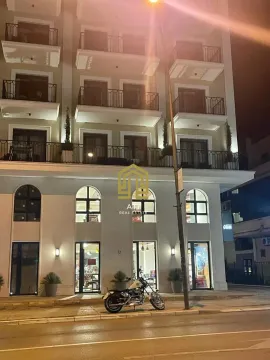 Exterior of a multi-family building at night with illuminated facade and balconies. - image 20
