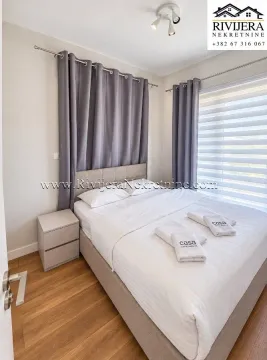 Spavaća soba sa bračnim krevetom, sivim zavjesama i noćnim stočićem. - image 7