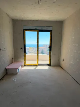 Neopremljena prostorija u sivoj fazi sa pogledom na more kroz balkonska vrata. - image 3