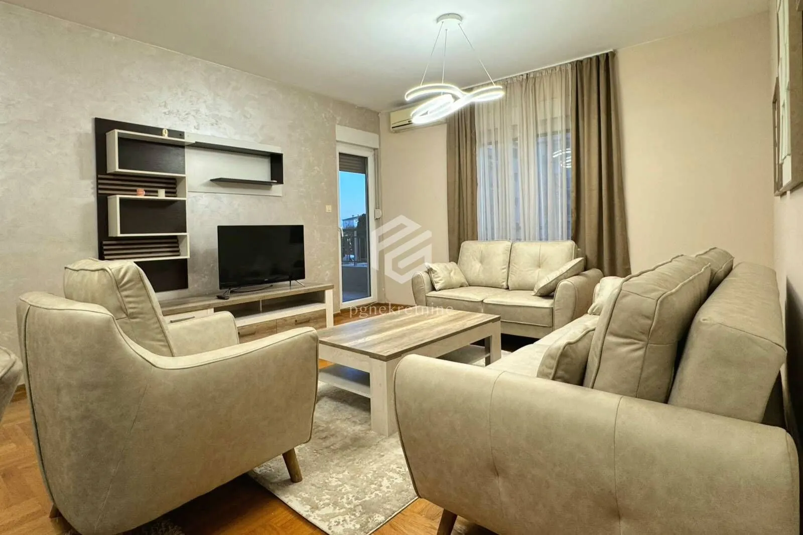 Living room with a sofa set, coffee table, and TV unit.