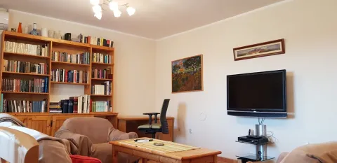 Svijetla dnevna soba sa policama za knjige, foteljama i televizorom. - image 3