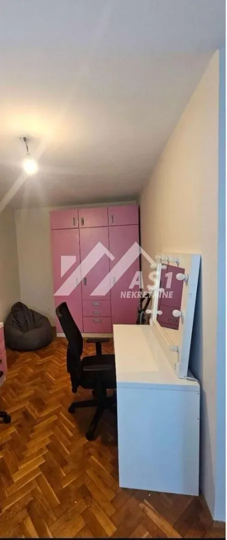 Dečja spavaća soba sa roze ormarom i radnim stolom.